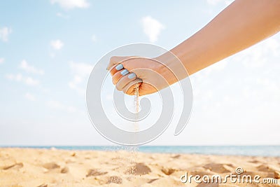 Womanâ€™s hand pours sand outdoor. Stock Photo